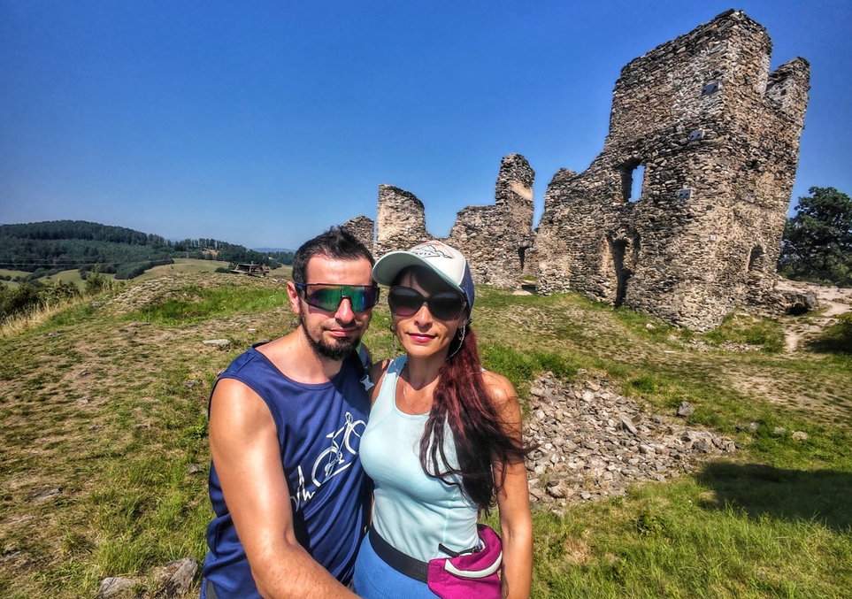 Para turystów na tle ruin zamku Brníčko na Północnych Morawach w Czechach, w letni, słoneczny dzień