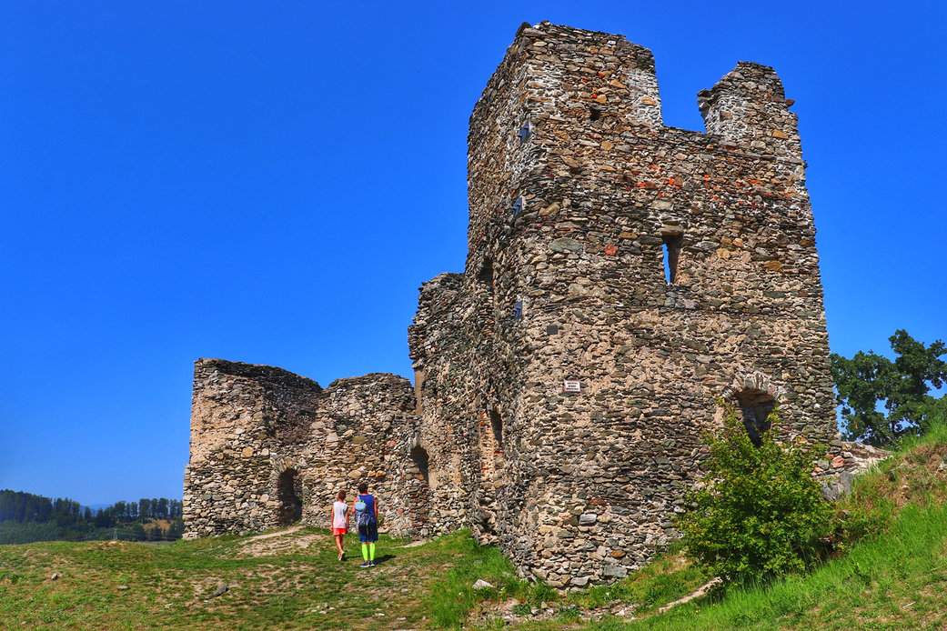 Turysta z dzieckiem zwiedzający ruiny zamku Brníčko w Czechach, niebieskie niebo