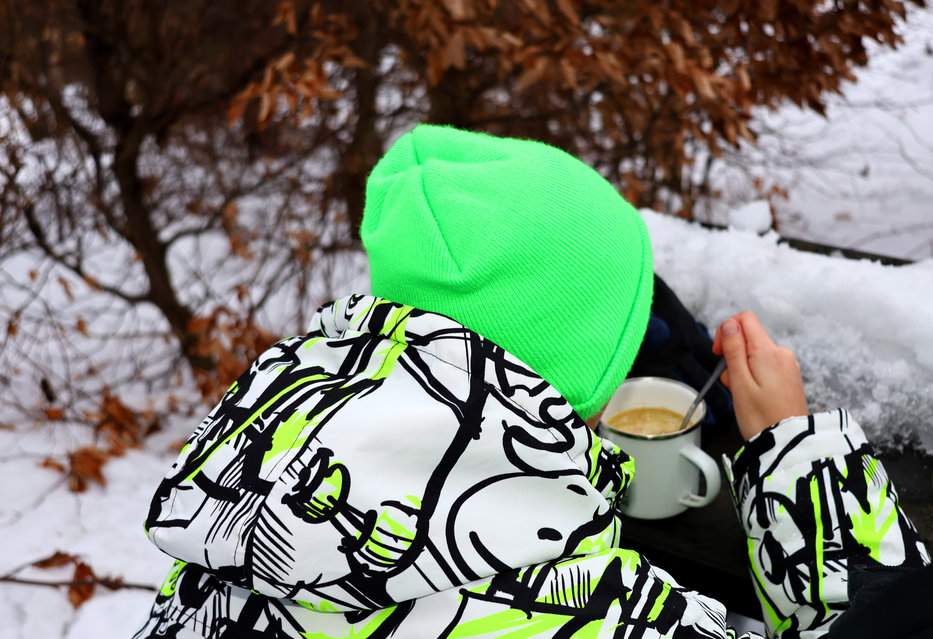 Dziecko jedzące ciepłą zupę z emaliowanego kubka na słowackim szlaku