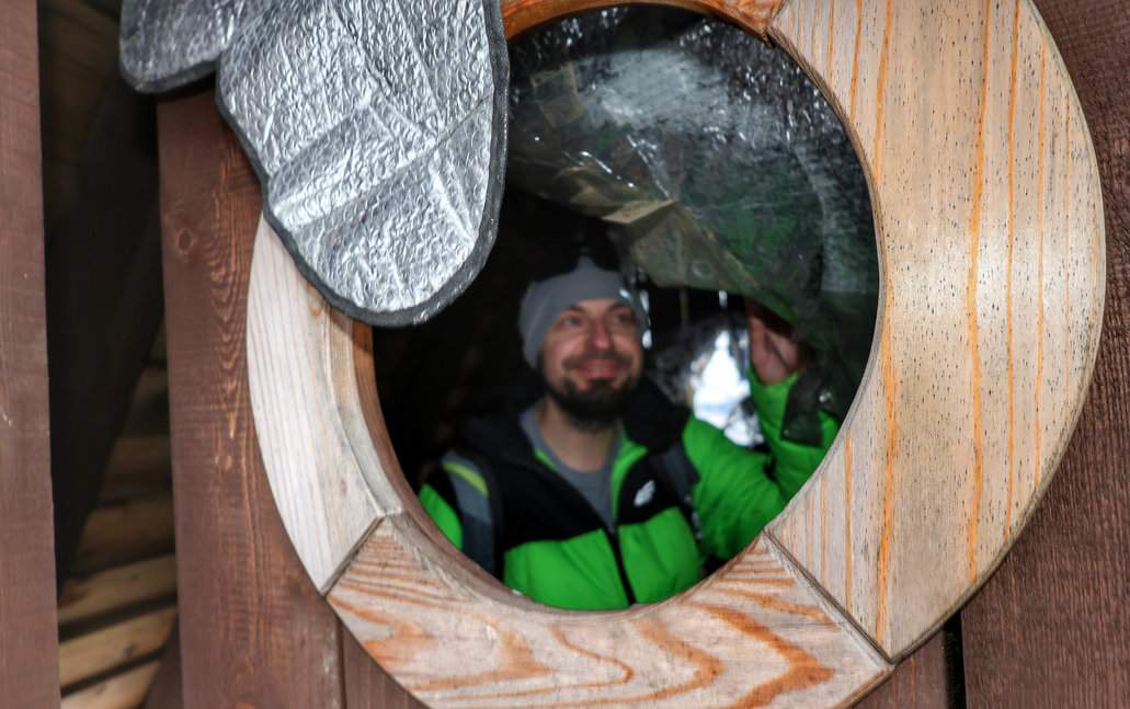 Uśmiechnięty turysta przy drewnianym okienku schronu turystycznego na słowackim szlaku