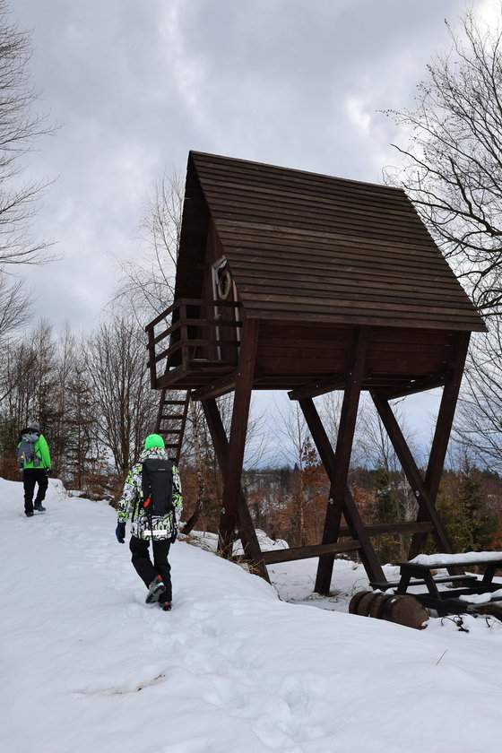 Turysta z dzieckiem przy schronie turystycznym na szlaku na Słowacji - zimowa aura