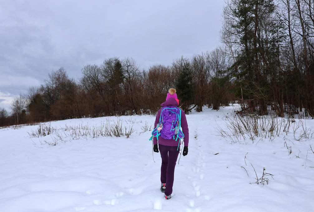 Turystka w drodze na Gładki Wierch na Słowacji, zaśnieżona ścieżka prowadząca przez rozległą polanę