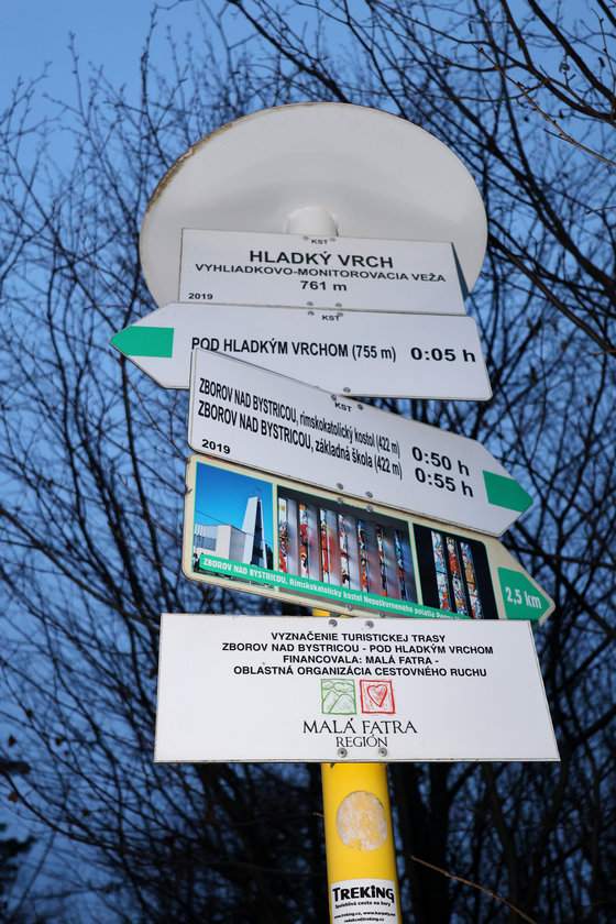 Słup z drogowskazami (szlak zielony) – biała tabliczka z napisem - Hladký vrch