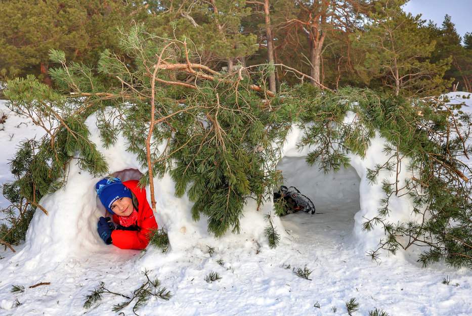 Dziecko leżące w śnieżnym schronie na plaży w Helu, na Półwyspie Helskim