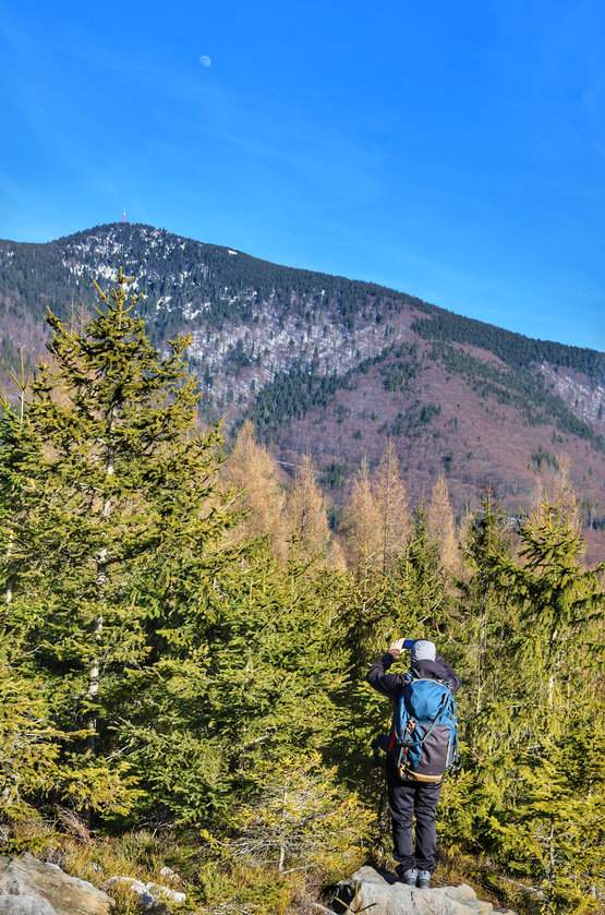 Turysta, formacje skalne Liščí díry w Beskidzie Morawsko-Śląskim, widok na Łysą Górę (Łysa Hora)