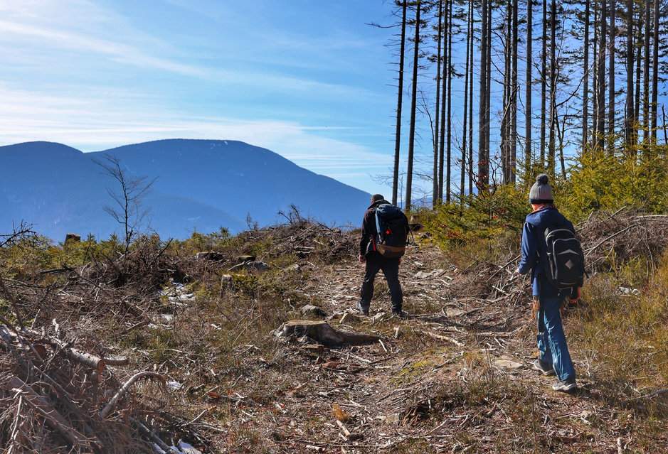 Turysta z dzieckiem idący do punktu widokowego u podnóża szczytu Smrčina w Beskidzie Morawsko-Śląskim