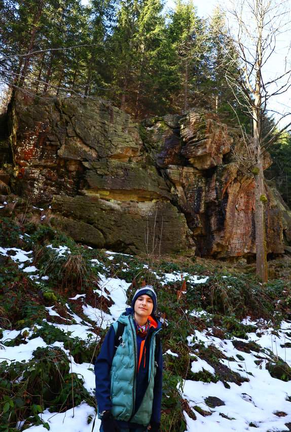 Uśmiechnięte dziecko na niebieskim szlaku w Ostravice, w tle formacja skalna Dolní Mazák