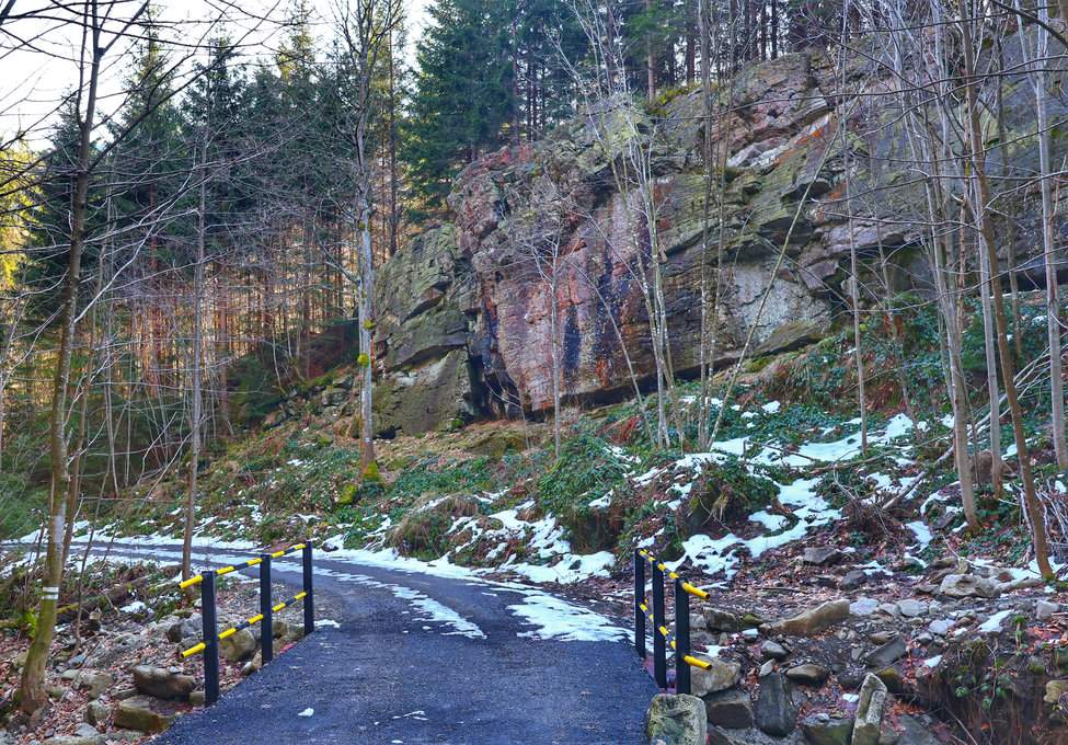 Szeroka droga leśna na niebieskim szlaku w Ostravice, formacja skalna Dolní Mazák