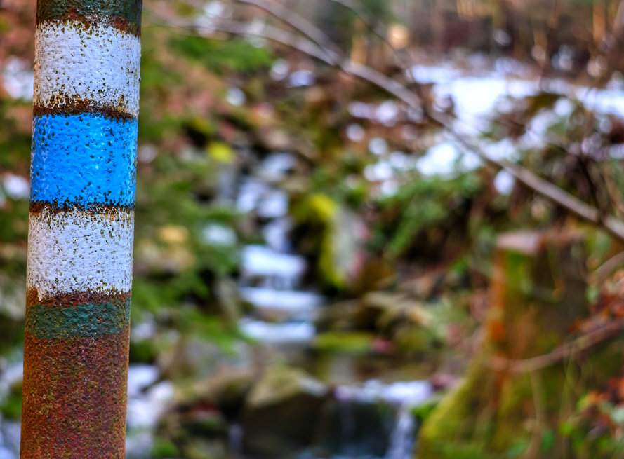 Oznaczenie niebieskiego szlaku na metalowym słupie przy Potoku Suchý Potok - Ostravice, Mazák
