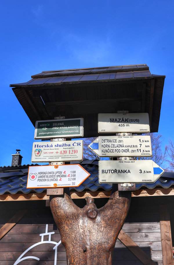 Ostravice – słup z białą tabliczką z napisem ‘Mazák (BUS) 435 m’, drogowskazy (szlak niebieski)