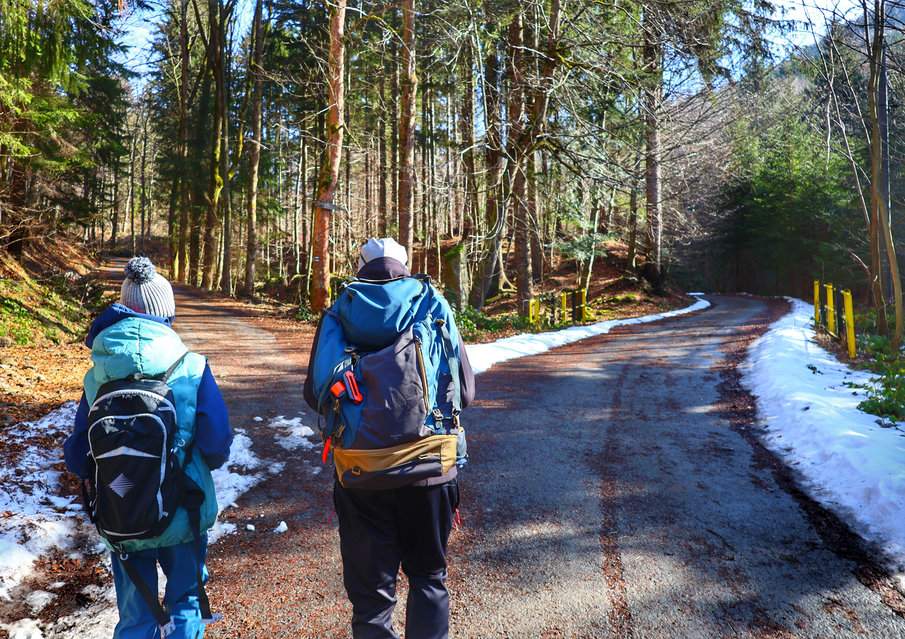 Miejsce skrętu w lewo szlaku niebieskiego - Ostravice, Mazák; turysta z dzieckiem na leśnej drodze