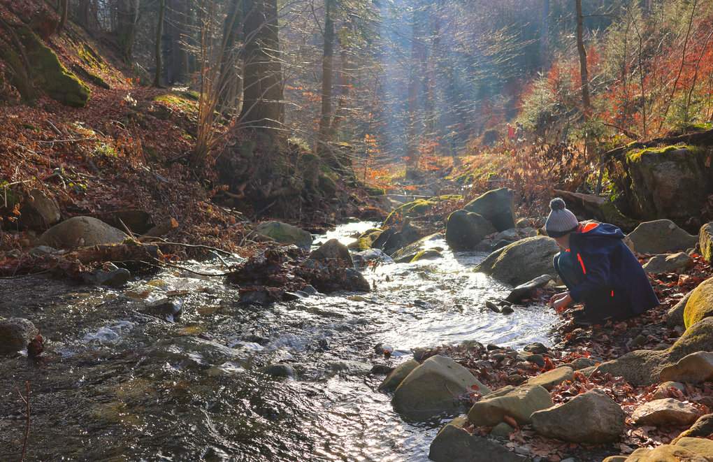 Dziecko bawiące się w Potoku Mazák przy niebieskim szlaku turystycznym