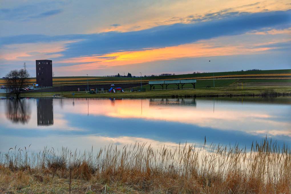 Widok na zalewisko „Źródlana Oaza” i wieżę widokową w Marklowicach na Śląsku o zachodzie słońca