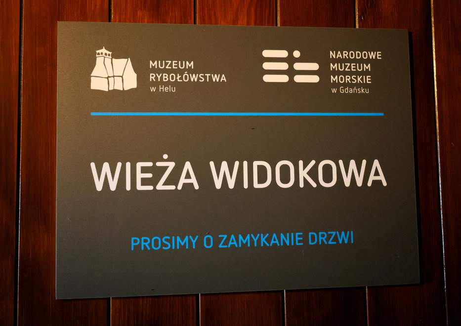 Tabliczka wskazująca wejście na wieżę widokową w Muzeum Rybołówstwa w Helu