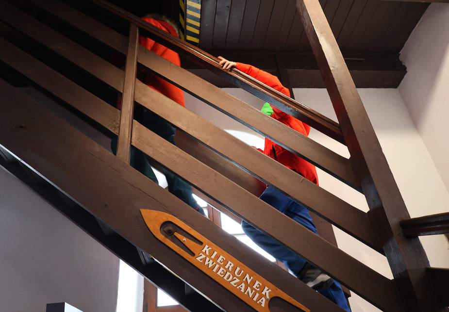 Dziecko wchodzące po stromych schodach prowadzących na wieżę widokową w Muzeum Rybołówstwa w Helu