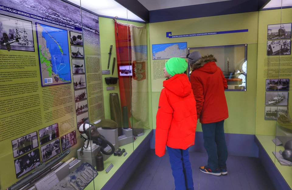 Turysta z dzieckiem oglądający eksponaty w Muzeum Rybołówstwa w Helu