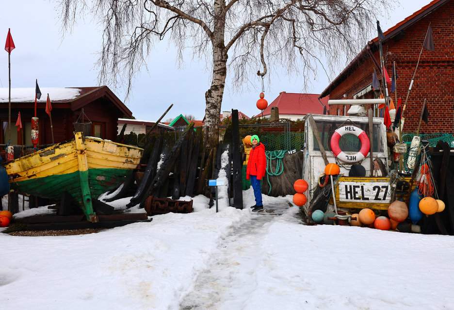 Dziecko zwiedzające skansen starych łodzi rybackich przy Muzeum Rybołówstwa w Helu