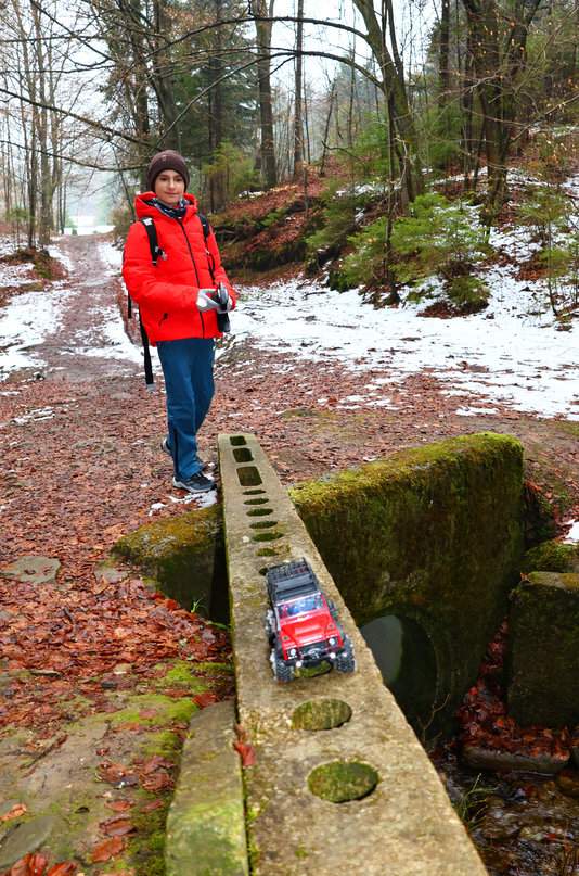 Szczęśliwe dziecko sterujące samochodem RC Traxxas w beskidzkim lesie, czarny szlak w Wilkowicach