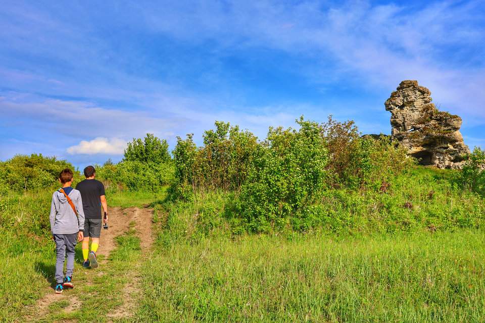 Turysta z dzieckiem na polnej ścieżce prowadzącej do Triasowej Skałki w Bolęcinie