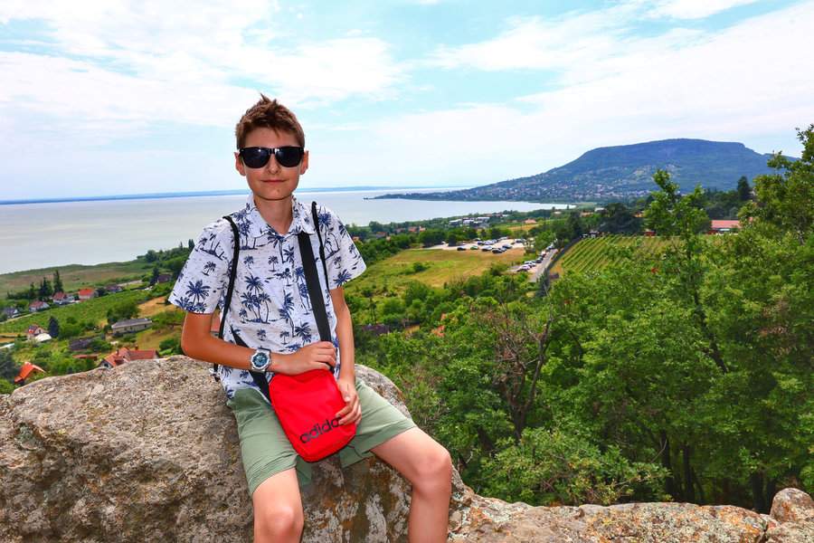 Dziecko na skalnym punkcie widokowym Bagolyszikla w Ábrahámhegy. W tle rozciąga się widok na Balaton i Badacsony
