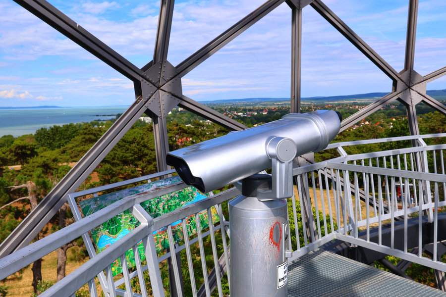 Teleskop widokowy i tablica z panoramą na wieży widokowej János Xantus Gömbkilátó w Balatonboglár - w tle turkusowa tafla Balatonu