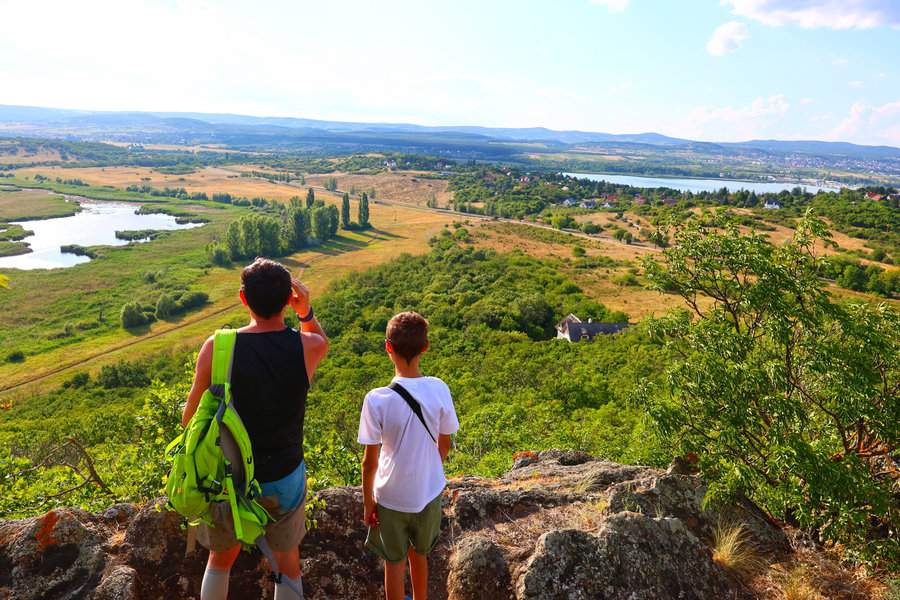 Turysta z dzieckiem podziwiający malowniczą panoramę ze skalnego punktu widokowego na górze Kis-erdő-tető na Półwyspie Tihany